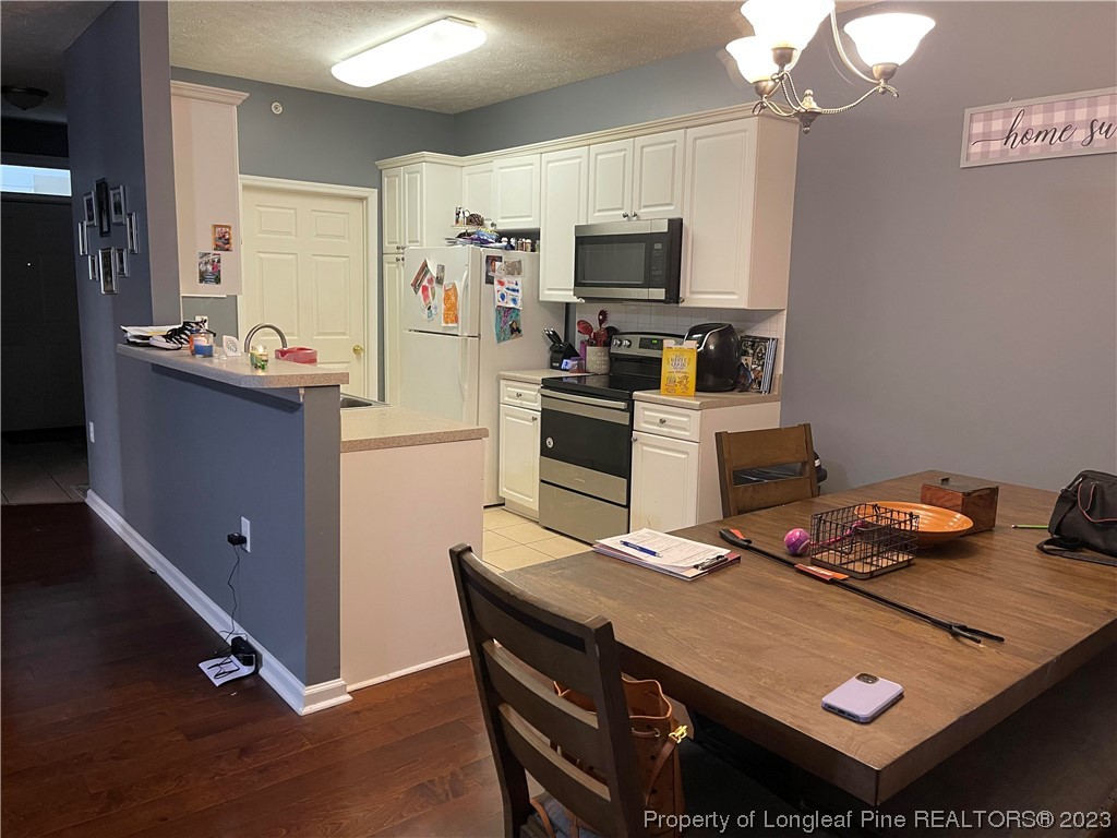 649 Brandermill Road, Unit 203 Fayetteville, NC 28314 - Photo 6 of 26 a kitchen with stainless steel appliances granite countertop a sink dishwasher stove and refrigerator with wooden floor