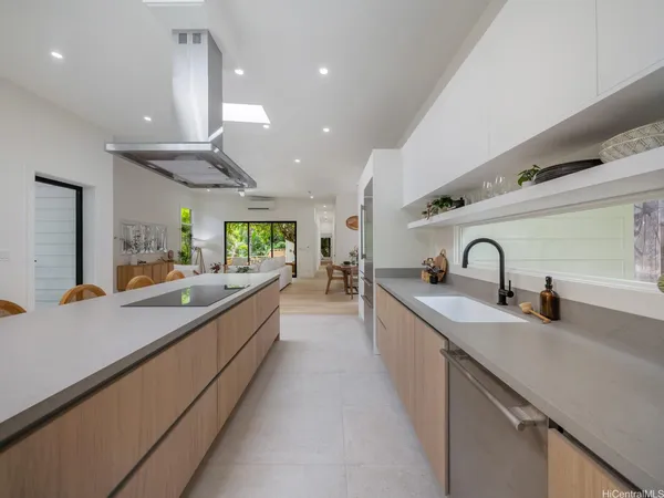a large kitchen with stainless steel appliances a sink and a large counter top