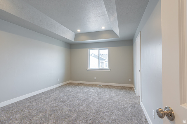 2257 South 1090 West, Unit 74 Nibley, UT 84321 - Photo 15 of 40 Spacious room featuring a tray ceiling with recessed lighting, light gray walls, a window with white trim, and gray carpet flooring