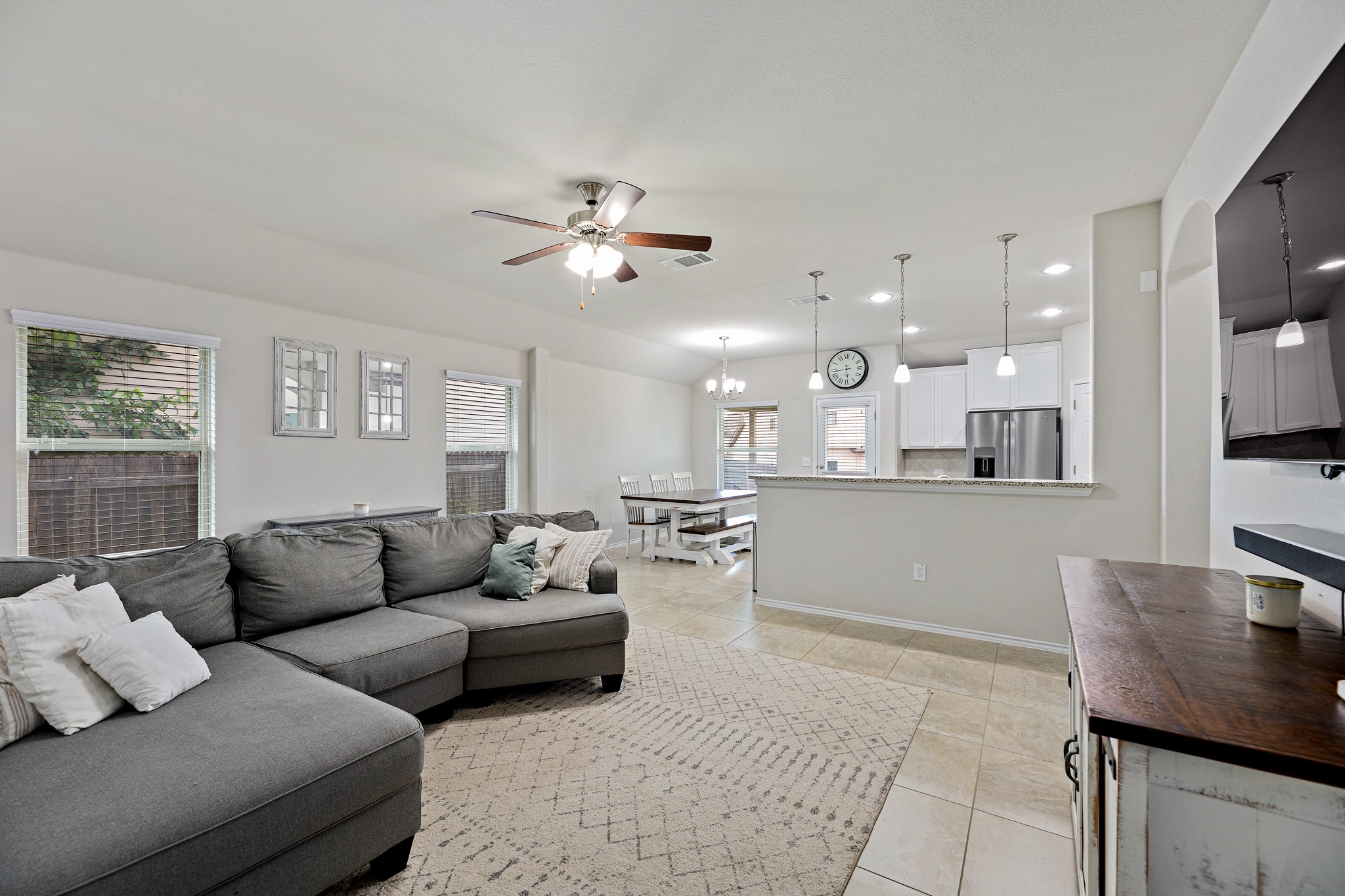 382 Limerick Road Buda, TX 78610 - Photo 7 of 20 An open concept living area boasts a kitchen with stainless steel appliances and pendant lighting.