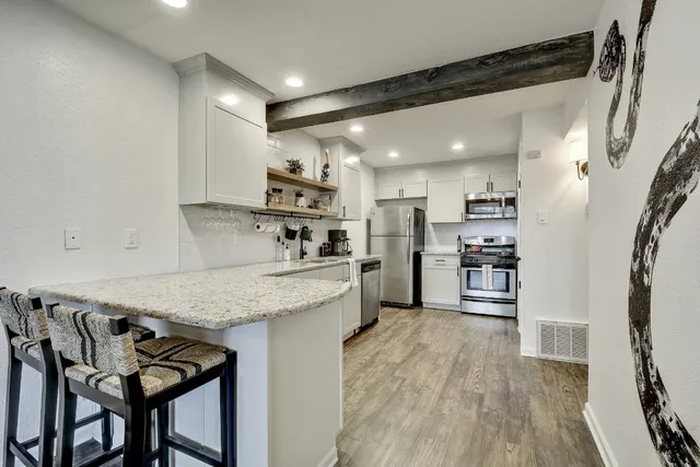 a kitchen with stainless steel appliances granite countertop a sink refrigerator and microwave