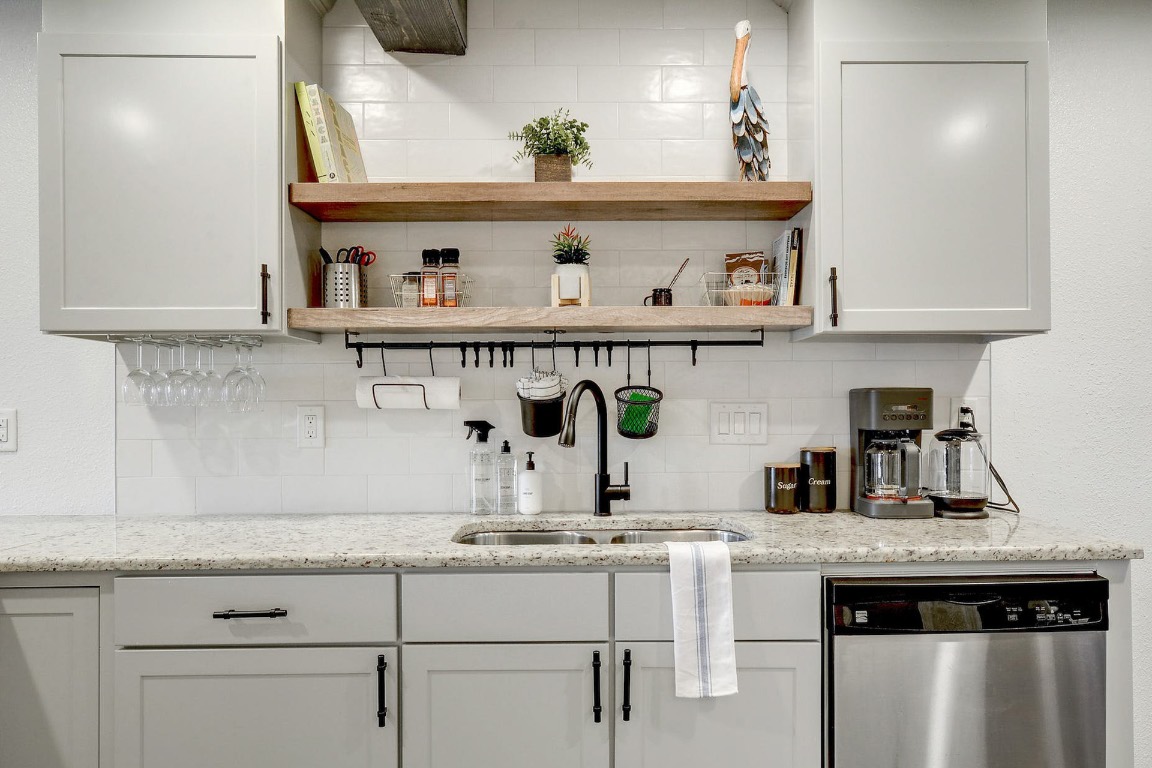 1202 Newning Avenue, Unit 202 Austin, TX 78704 - Photo 13 of 20 Bar featuring stainless steel dishwasher, light stone countertops, open shelves, white cabinetry, and backsplash
