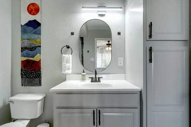 a bathroom with a toilet sink and mirror