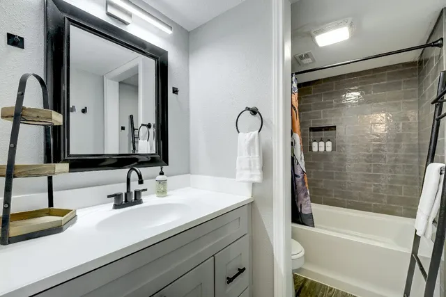 a bathroom with a sink a tub and a mirror