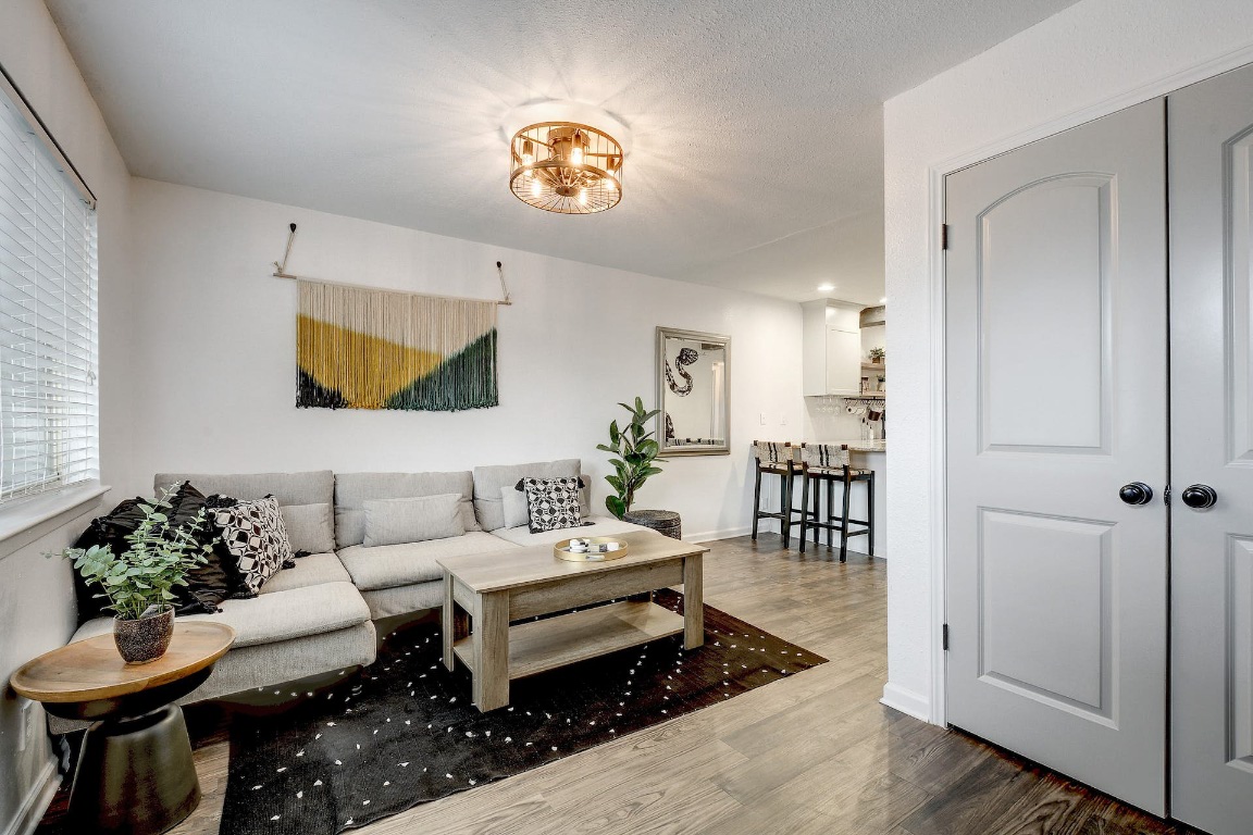 1202 Newning Avenue, Unit 202 Austin, TX 78704 - Photo 6 of 20 Living room with wood finished floors and a chandelier