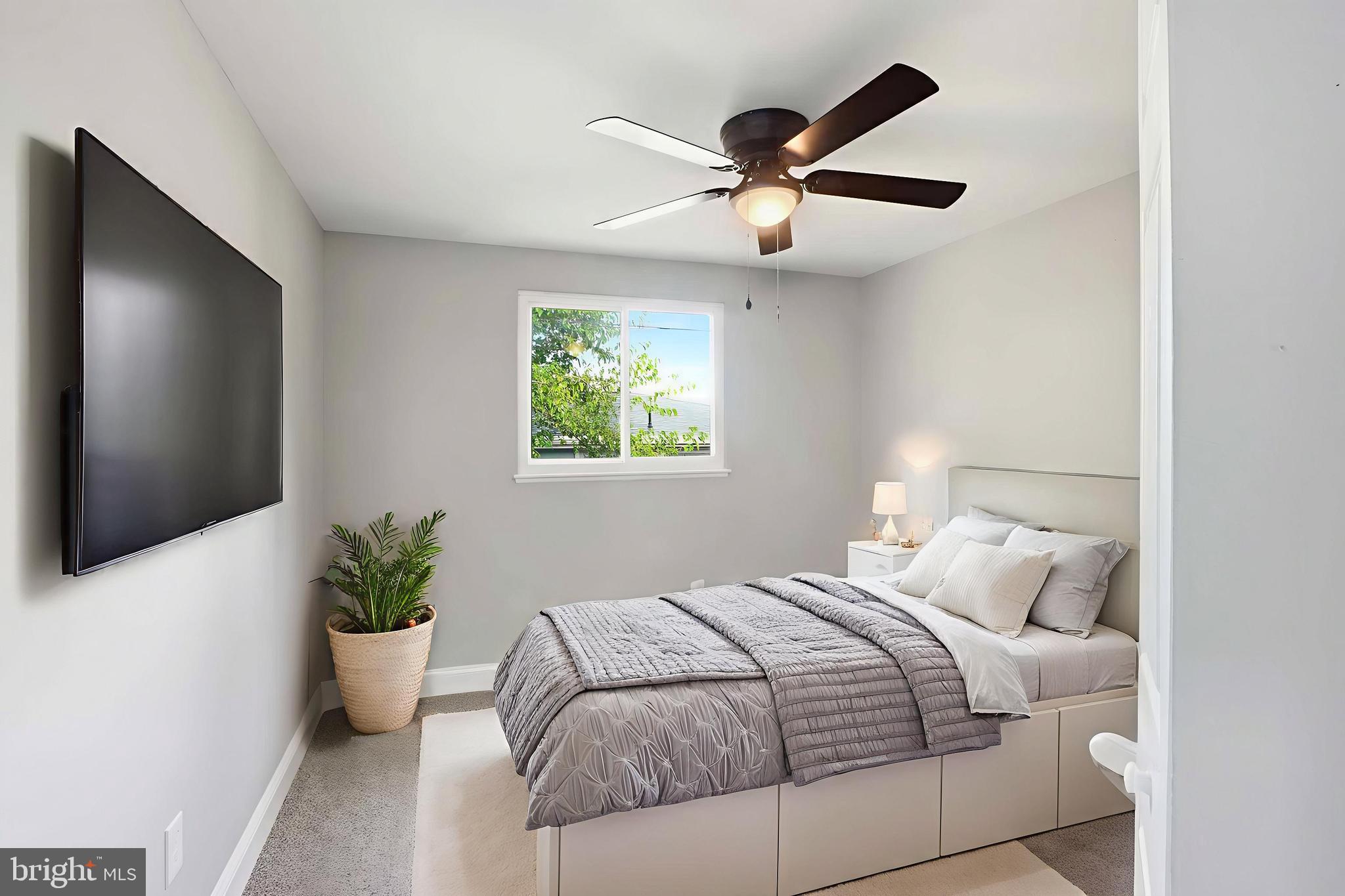 5006 Shelbourne Road Halethorpe, MD 21227 - Photo 25 of 48 a bedroom with a large bed and a potted plant