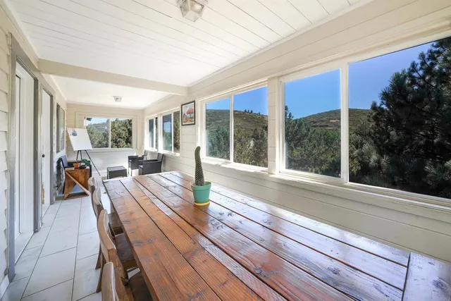 a view of a dining room with furniture large windows and wooden floor