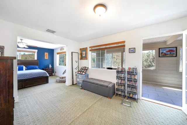 a bedroom with furniture and large window