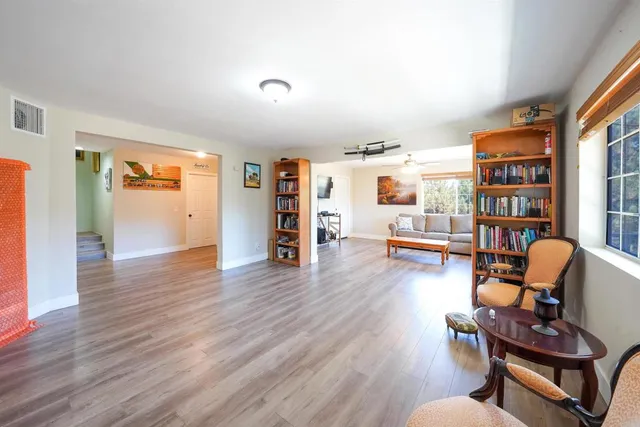 a living room with furniture wooden floor and a large window