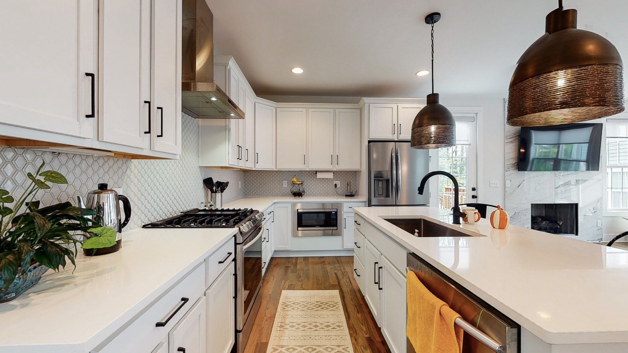 a kitchen with stainless steel appliances a sink a stove a chimney a sink and cabinets