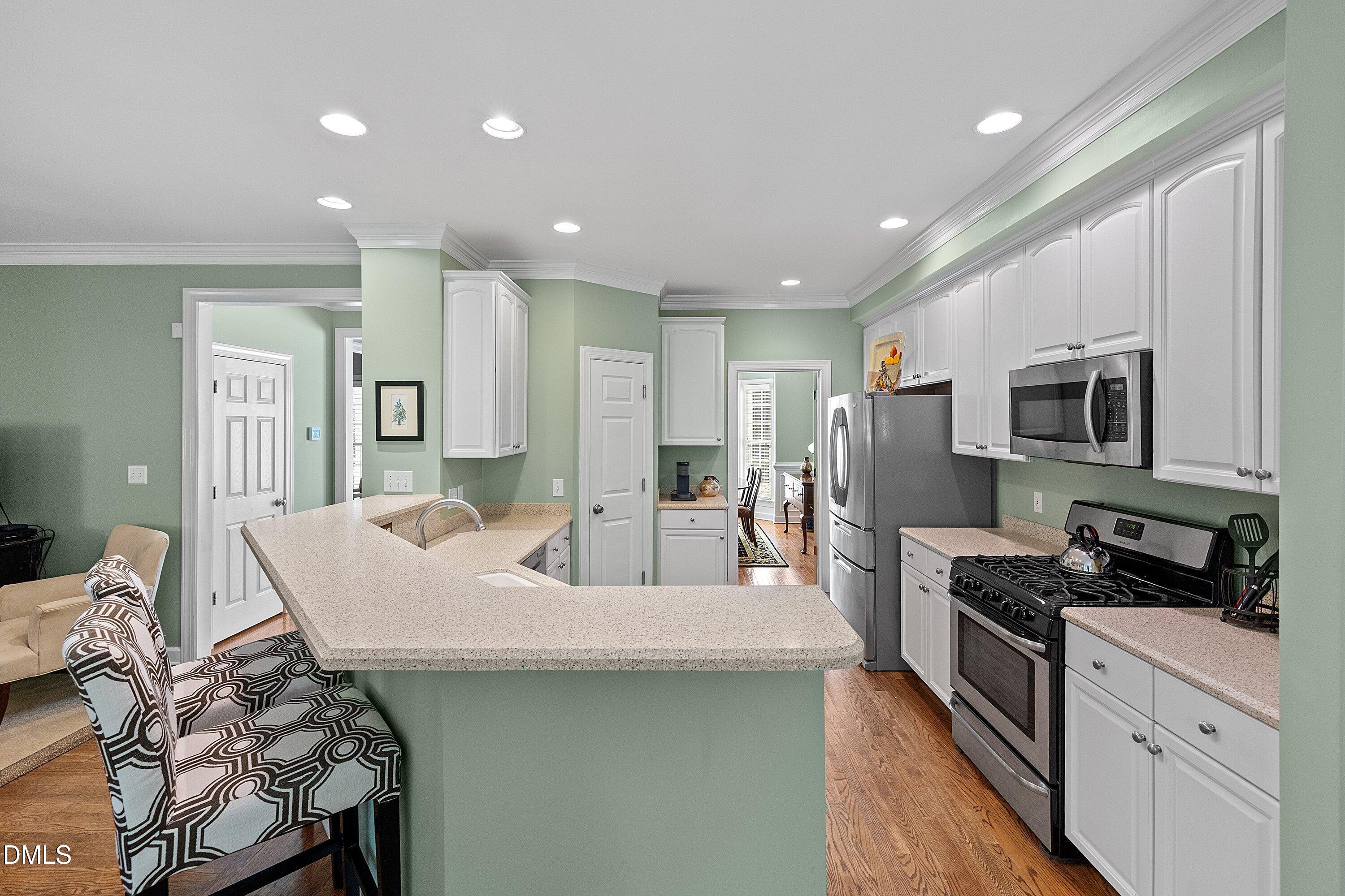 3914 Sterling Ridge Lane Durham, NC 27707 - Photo 22 of 66 Kitchen featuring white cabinetry, light-toned countertops, stainless steel appliances, and recessed lighting