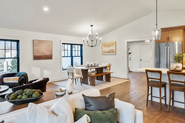 a view of kitchen with kitchen island stainless steel appliances wooden floor dining table and chairs