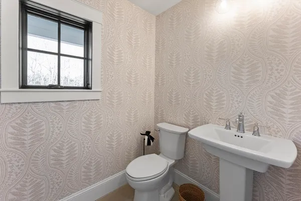 a bathroom with a toilet a sink and mirror