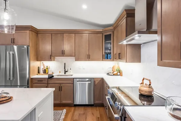 a kitchen with a sink a stove and wooden cabinets
