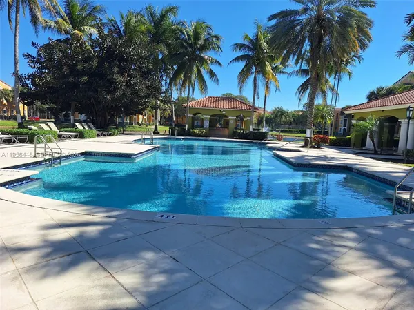 a swimming pool with outdoor seating yard and palm tree