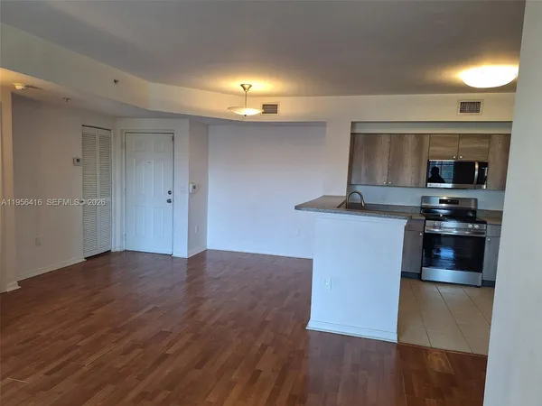 a kitchen with kitchen island granite countertop a stove and a refrigerator