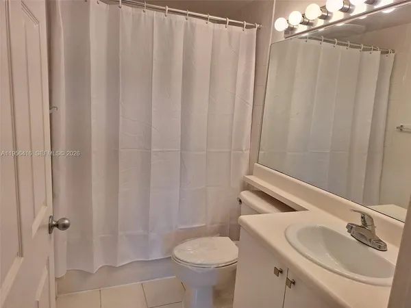 a bathroom with a sink a toilet and shower curtain