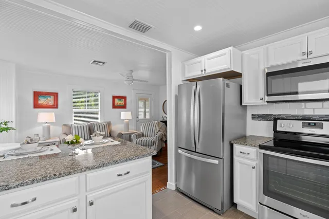 a kitchen with stainless steel appliances granite countertop a refrigerator sink and stove