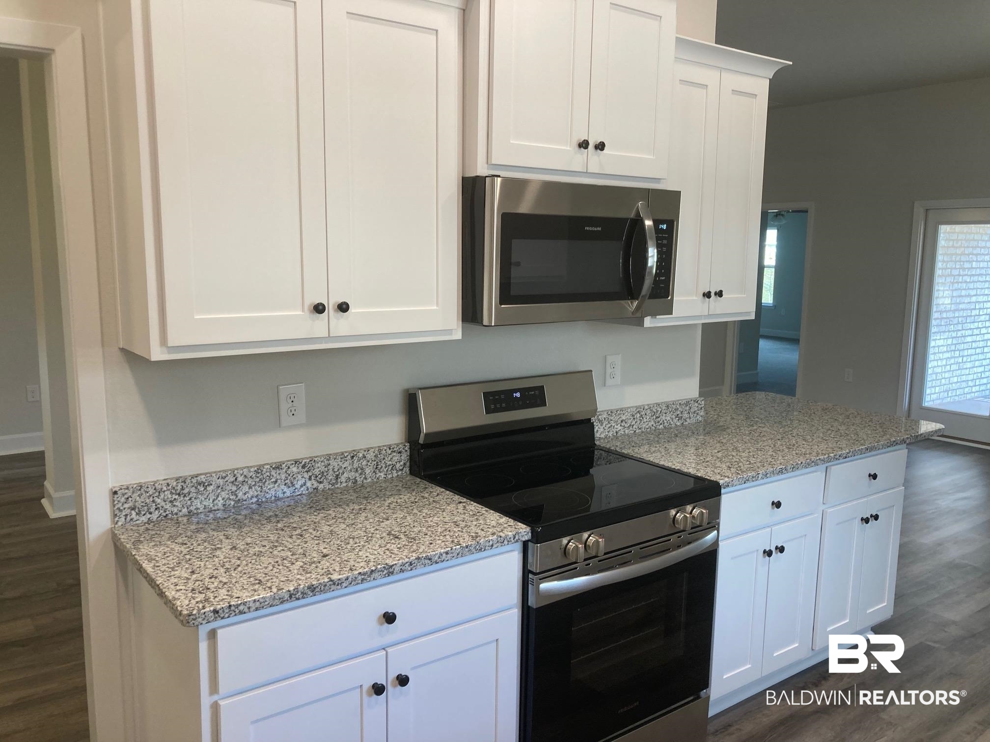 629 Revere Street Foley, AL 36535 - Photo 14 of 30 Kitchen featuring stainless steel appliances, white cabinetry, dark hardwood / wood-style floors, and light stone counters