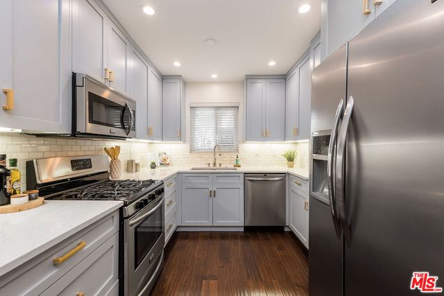 a kitchen with granite countertop stainless steel appliances and wooden cabinets