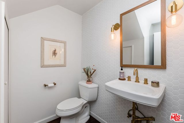 a bathroom with a toilet a sink and mirror