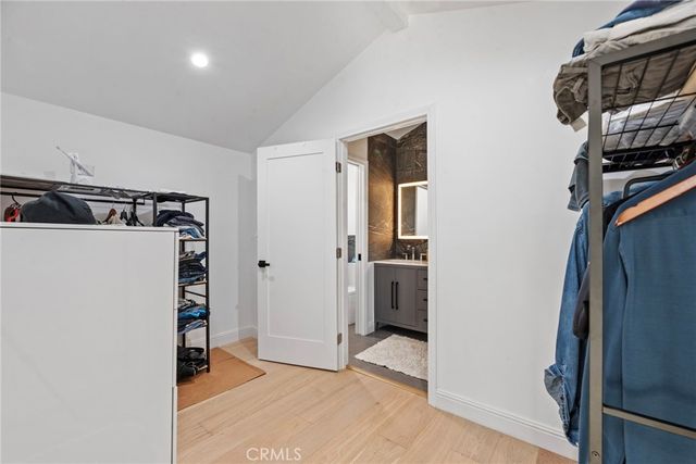 a view of walk in closet with clothes and shoes