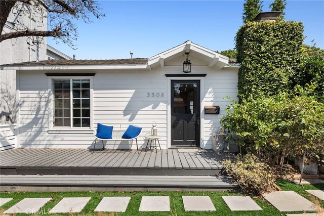 a view of a house with a small yard plants and large tree