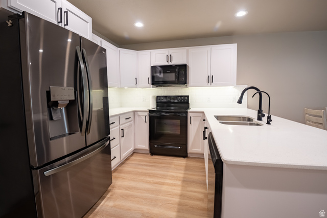 1787 North 1280 East Payson, UT 84651 - Photo 6 of 22 Kitchen featuring white cabinetry, light-toned wood-finish flooring, stainless steel French door refrigerator, black range, and white countertops with an undermount double-basin sink and matte black faucet