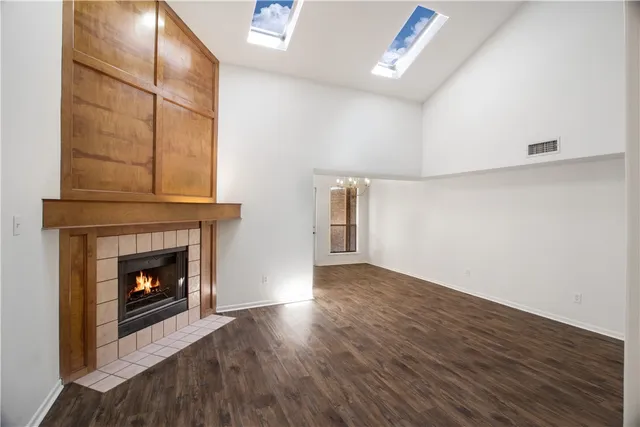 a living room with wooden floor and a fireplace