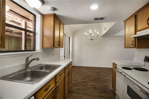 a kitchen with a sink cabinets and wooden floor