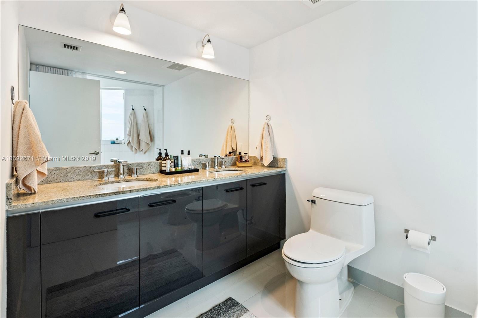 665 Northeast 25th Street, Unit 802 Miami, FL 33137 - Photo 12 of 24 a bathroom with a toilet sink and mirror