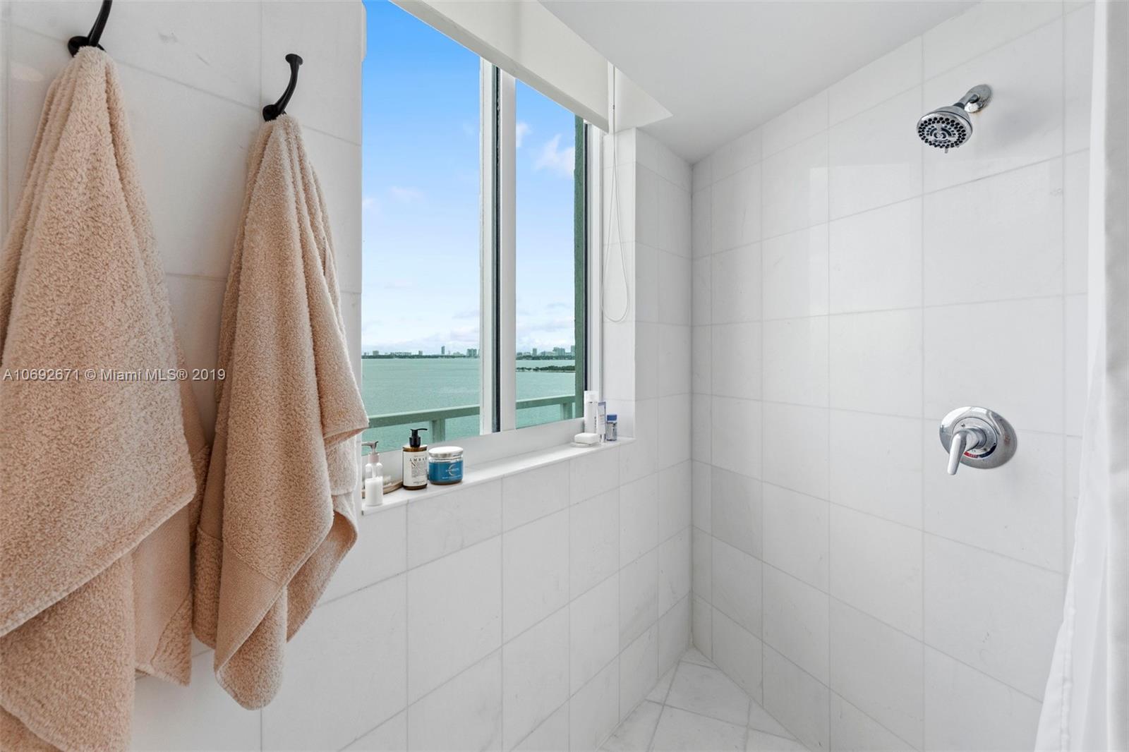 665 Northeast 25th Street, Unit 802 Miami, FL 33137 - Photo 13 of 24 a bath room with a shower curtain and a window
