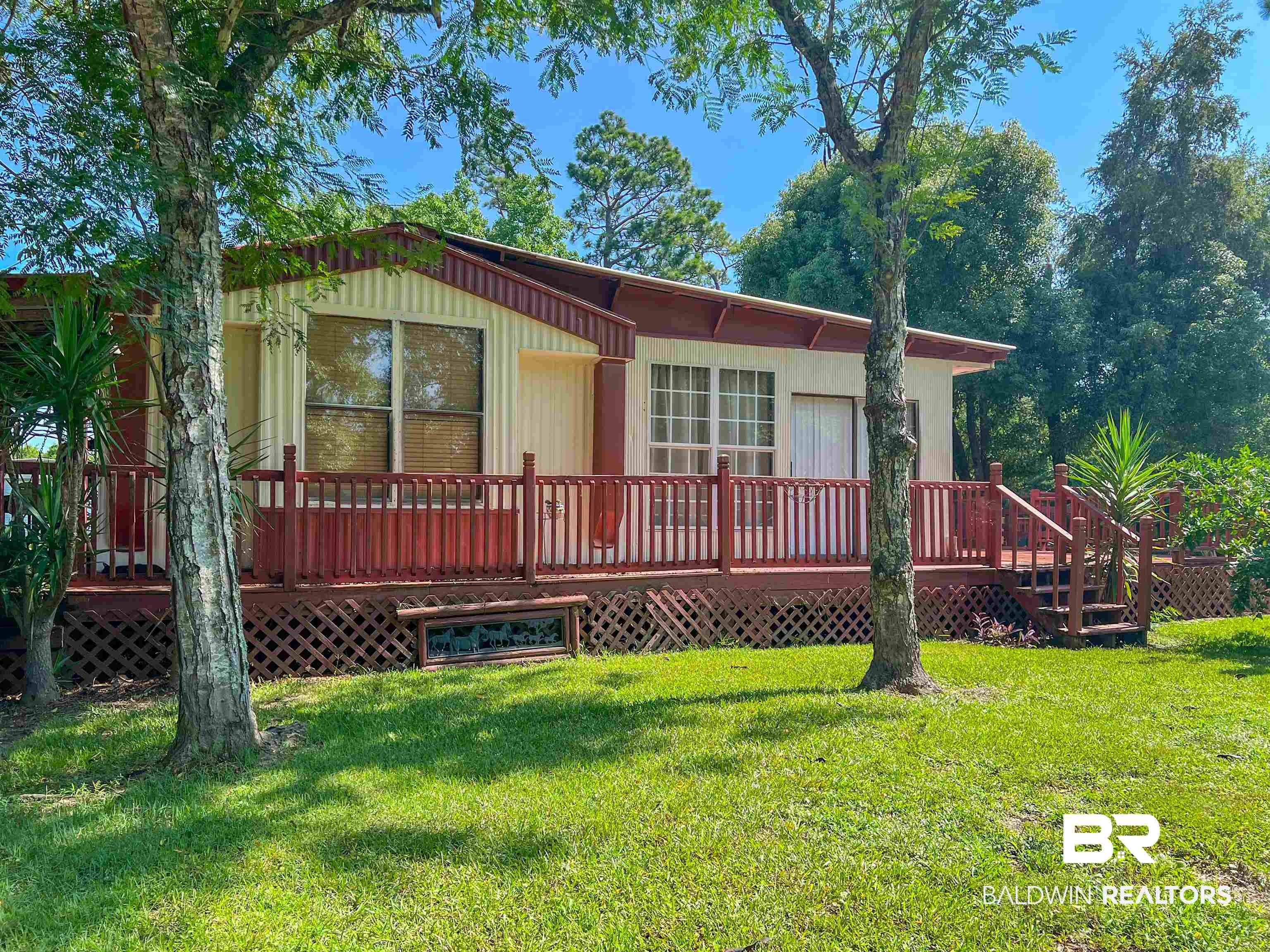 9190 County Road 97 Elberta, AL 36530 - Photo 1 of 53 View of front facade featuring a wooden deck and a front lawn
