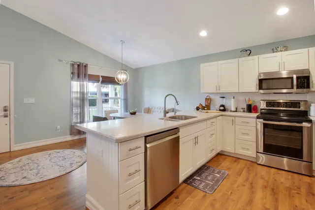 a kitchen with granite countertop cabinets stainless steel appliances and a counter space