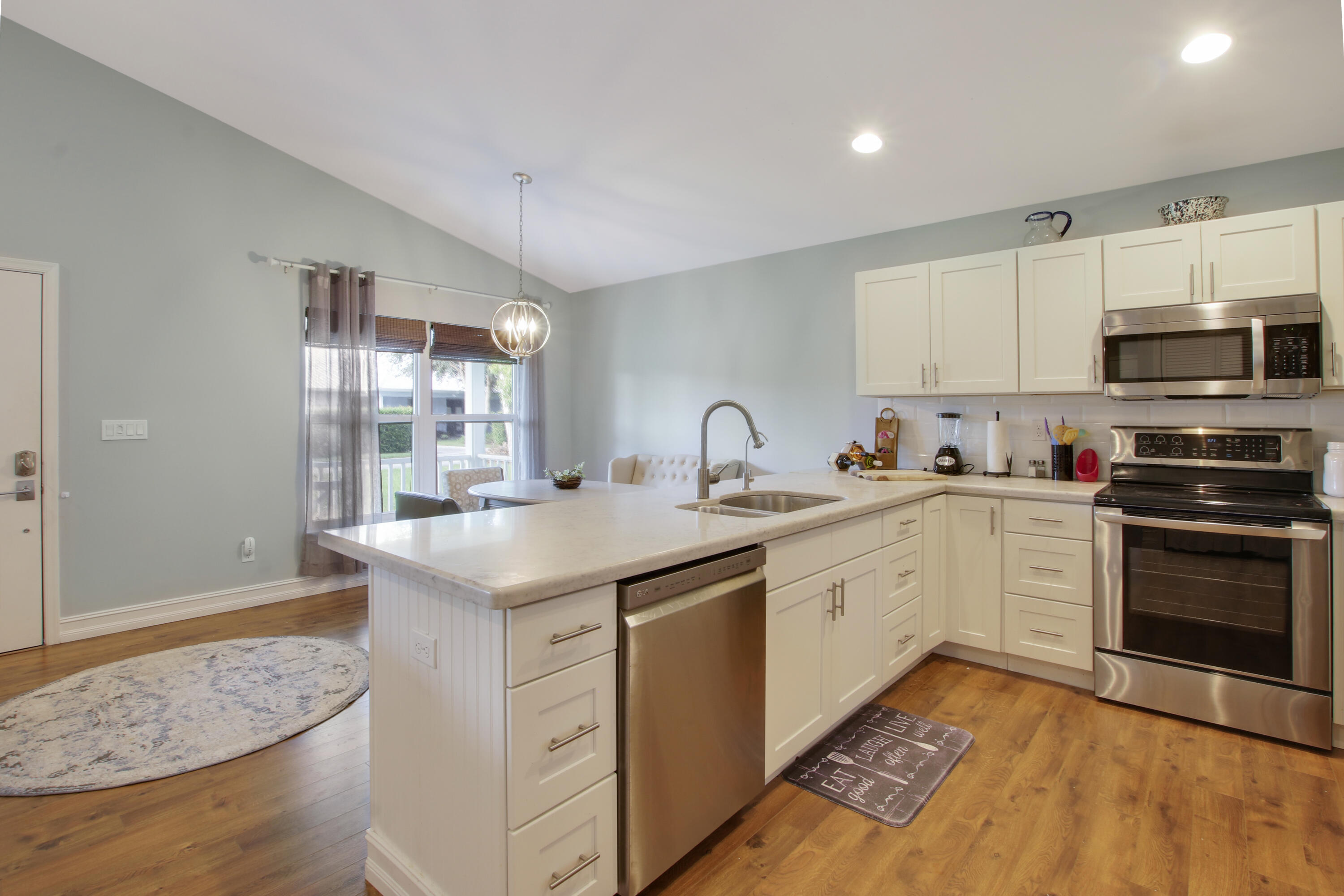 9155 Southeast Athena Street Hobe Sound, FL 33455 - Photo 11 of 25 a kitchen with granite countertop cabinets stainless steel appliances and a counter space