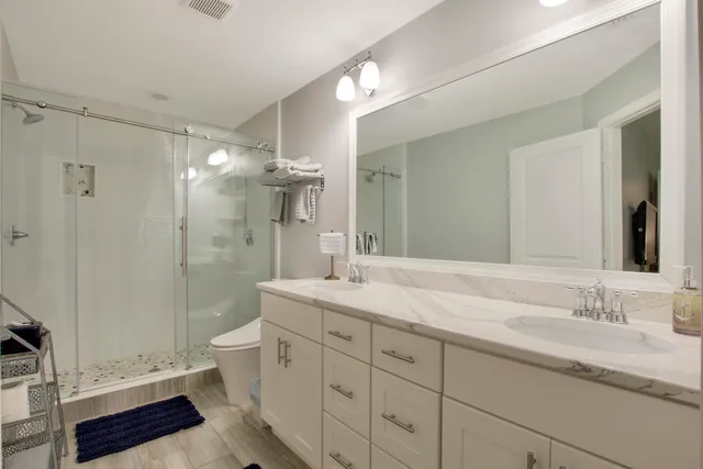 a bathroom with a double vanity sink toilet and shower