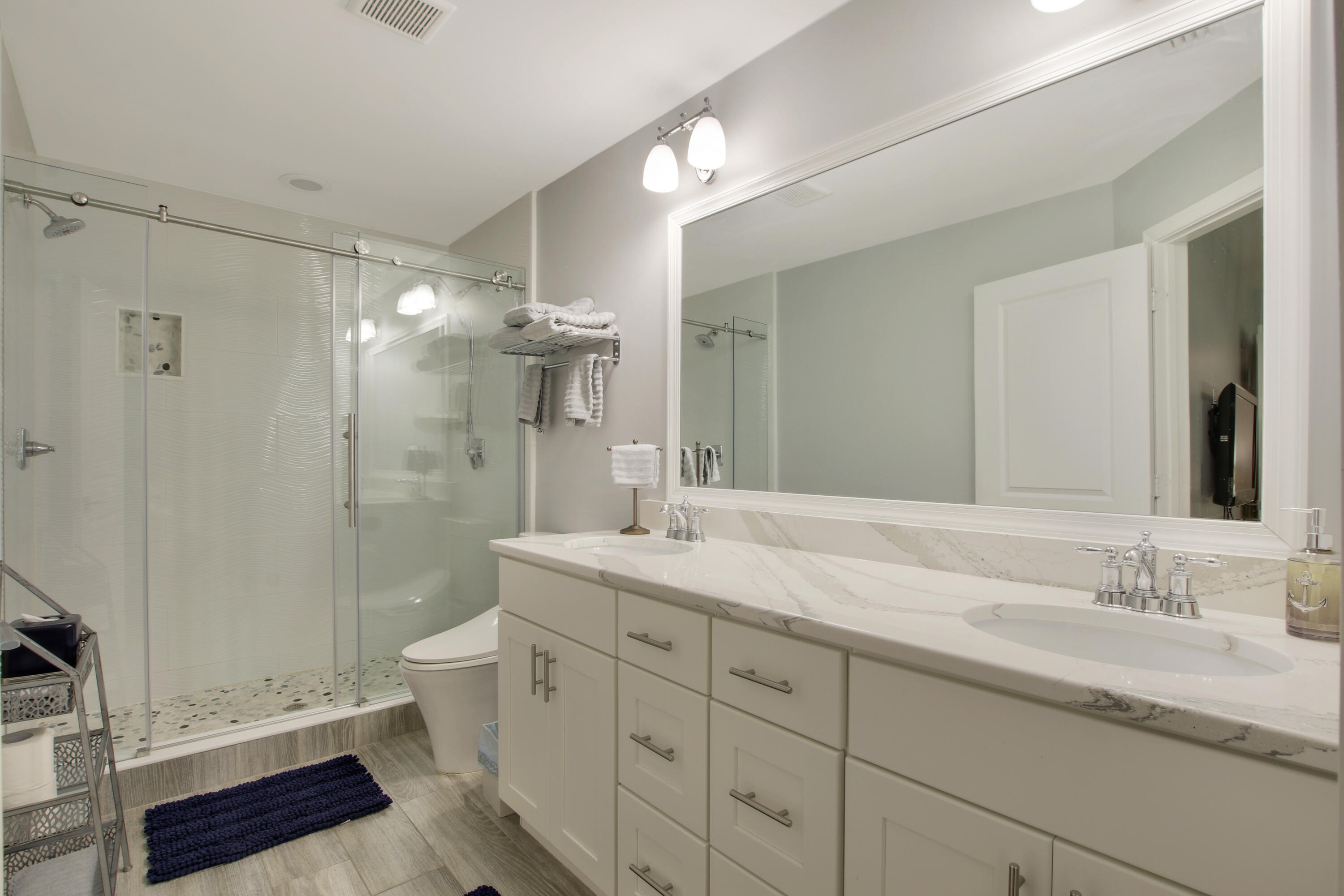 9155 Southeast Athena Street Hobe Sound, FL 33455 - Photo 17 of 25 a bathroom with a double vanity sink toilet and shower