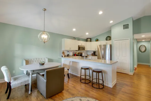 a kitchen with a dining table chairs refrigerator and cabinets