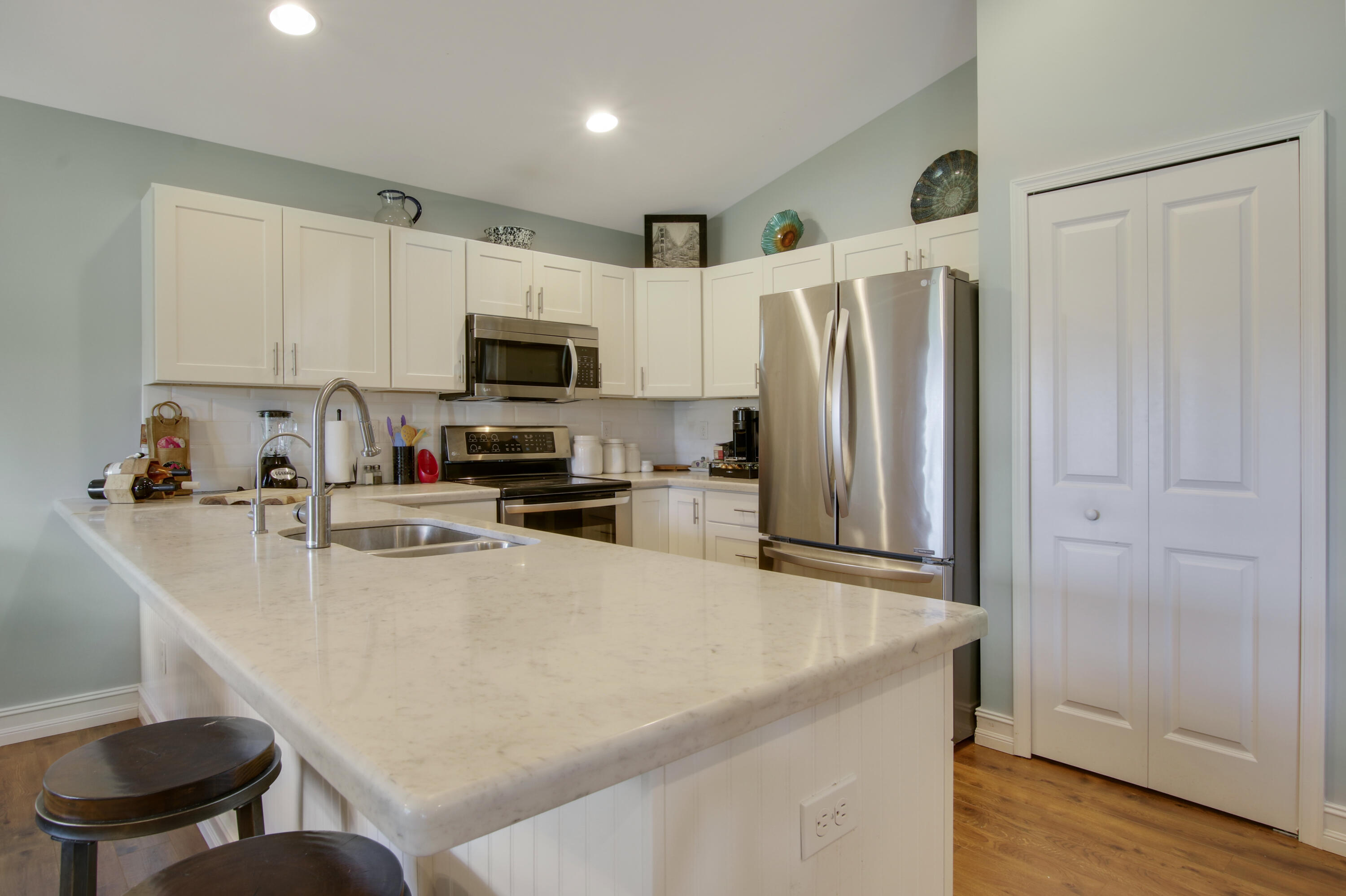 9155 Southeast Athena Street Hobe Sound, FL 33455 - Photo 9 of 25 a kitchen with stainless steel appliances a refrigerator stove microwave and sink