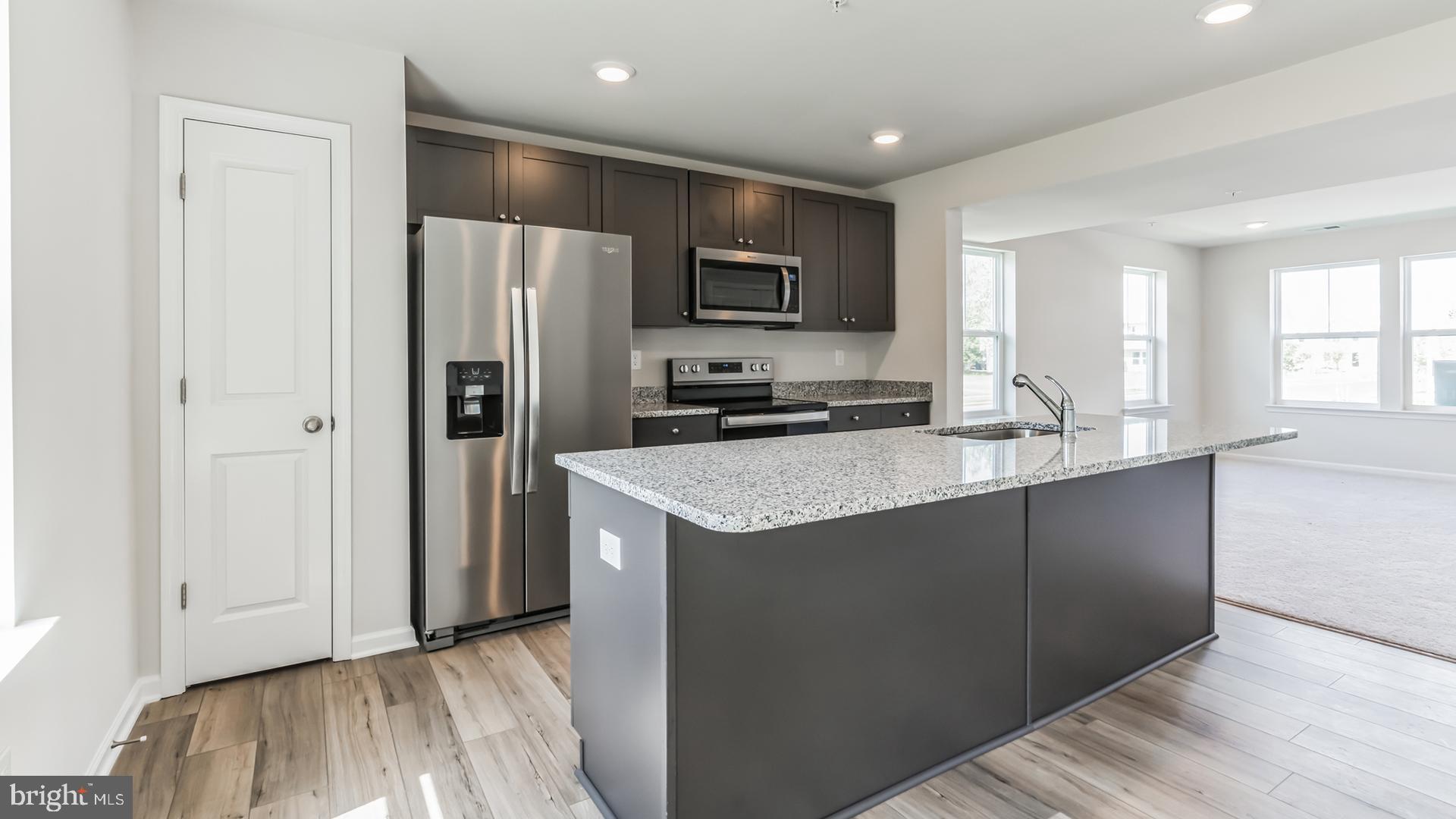 601 Widgeon Way Cambridge, MD 21613 - Photo 4 of 17 a kitchen with kitchen island granite countertop a refrigerator and a sink
