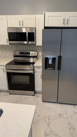 a kitchen with stainless steel appliances a stove a microwave and a refrigerator