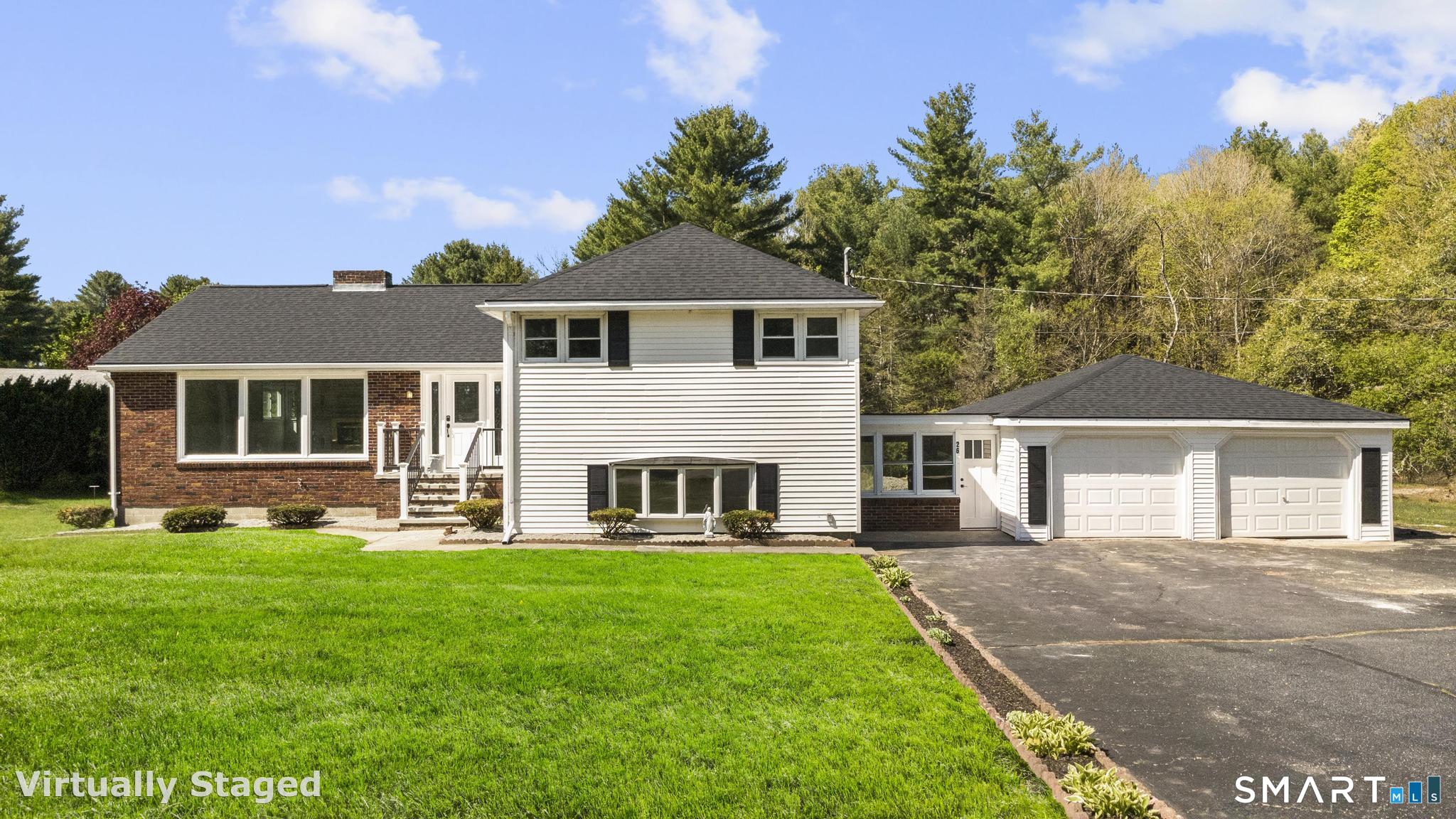 a front view of a house with a yard and trees