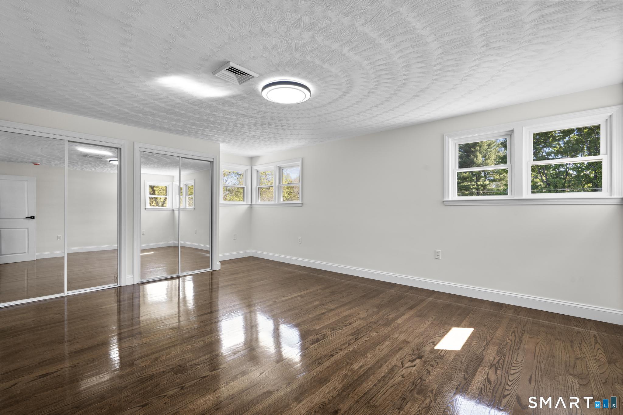 26 Quaddick Town Farm Road Thompson, CT 06277 - Photo 11 of 32 an empty room with wooden floor and windows