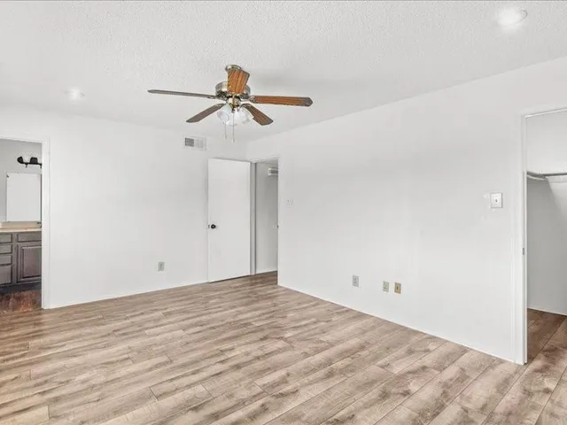 a view of room with wooden floor and ceiling fan