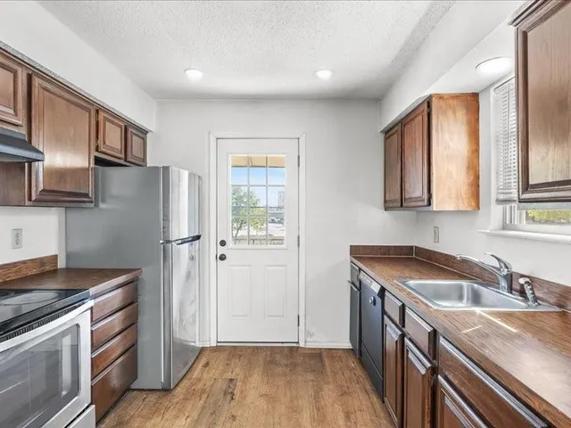 a kitchen that has a sink a refrigerator and cabinets