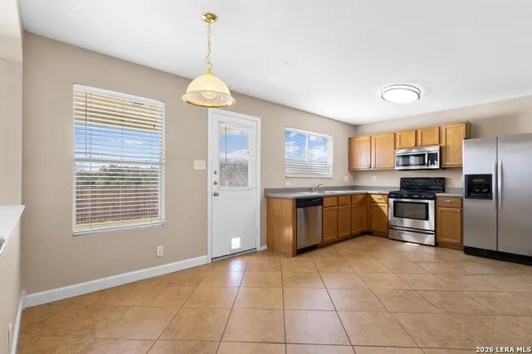 a large kitchen with granite countertop a stove cabinets and refrigerator
