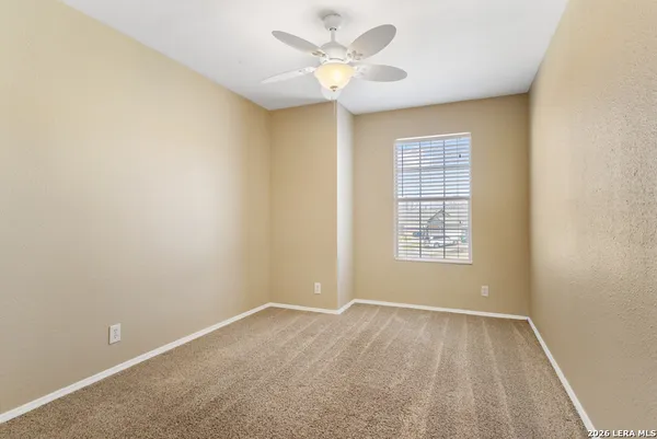an empty room with a window and a fan