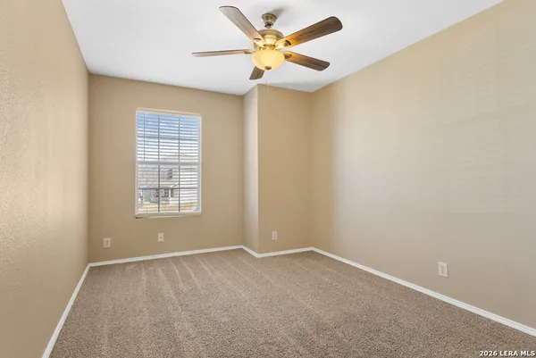 an empty room with a window and a fan