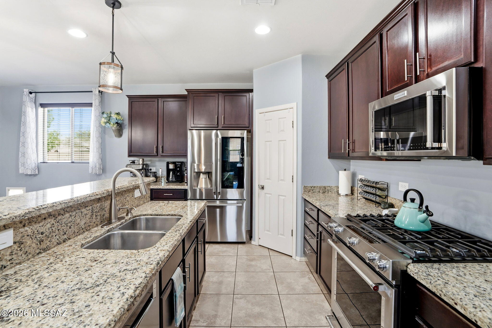 211 East Refuge Loop Vail, AZ 85641 - Photo 12 of 48 a kitchen with stainless steel appliances granite countertop a sink stove and refrigerator