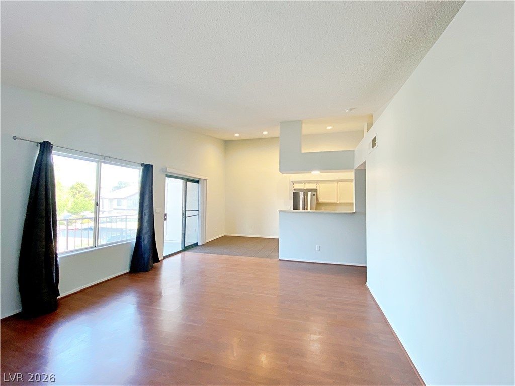 1575 West Warm Springs Road, Unit 1024 Henderson, NV 89014 - Photo 4 of 25 A living space offers a smooth transition to the kitchen, illuminated by recessed lighting and natural light from wide windows.